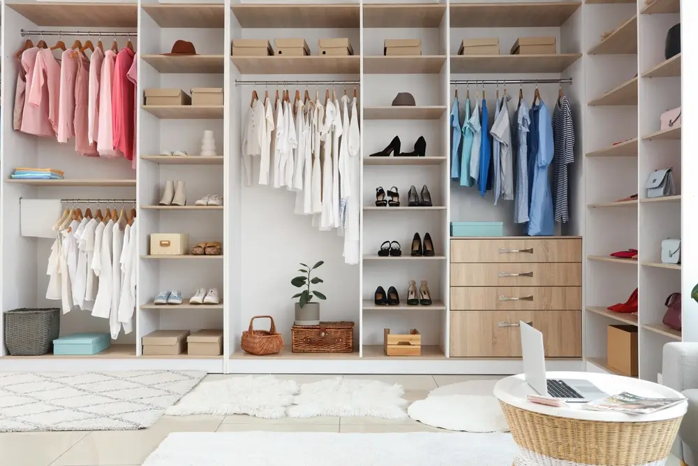 Armoire avec différents vêtements et accessoires dans le dressing.