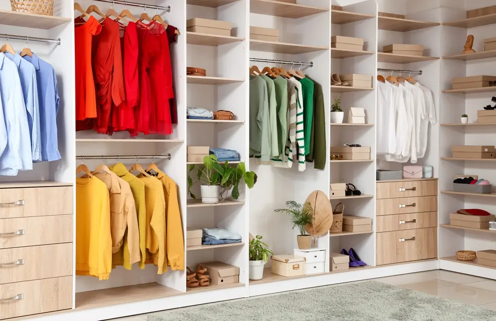 Grande armoire avec différents vêtements et accessoires stylisés dans le dressing.